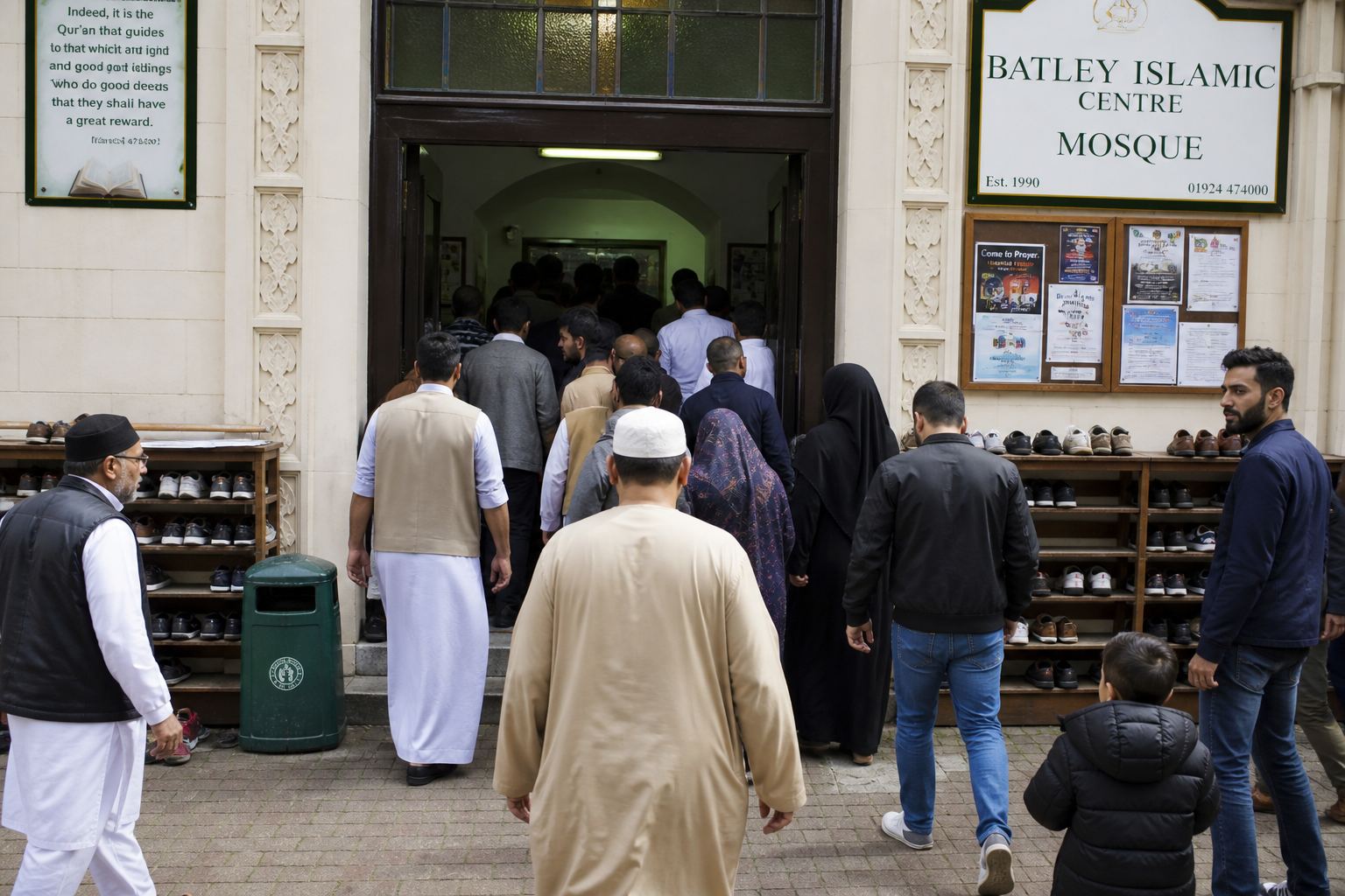People arriving for Friday prayer, shoes on the racks.