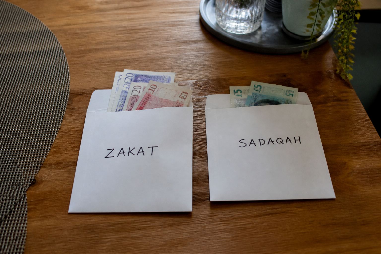 Two envelopes labelled zakat and sadaqah.